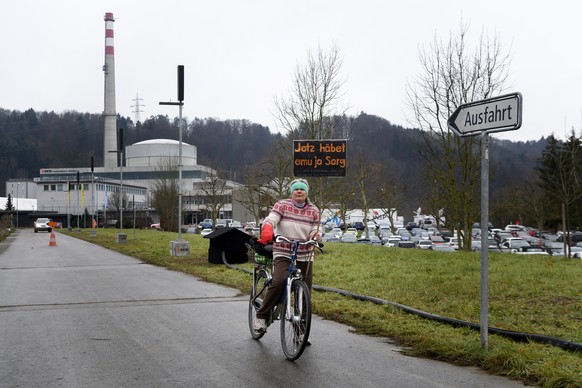 A person with a sign on a bicycle pictured during the official shutdown of the Muehleberg nuclear power plant after 47 years of operation, on Friday, 19 December 2019, in Muehleberg, Switzerland. The  ...