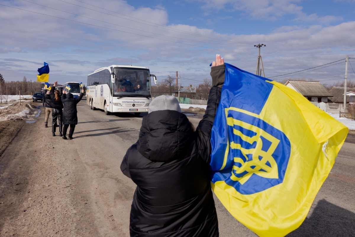 People with Ukrainian flags welcome Ukrainian prisoners of war (POW) following a prisoner exchange in the Chernihiv region on March 6, 2026, amid the Russian invasion of Ukraine. Their northern Cherni ...