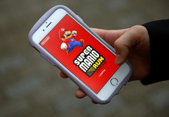 Takuya Nishya shows Nintendo&#039;s &quot;Super Mario Run&quot; game on his smartphone by the request of a photographer in Tokyo, Japan, December 20, 2016. Picture taken on December 20, 2016. REUTERS/ ...