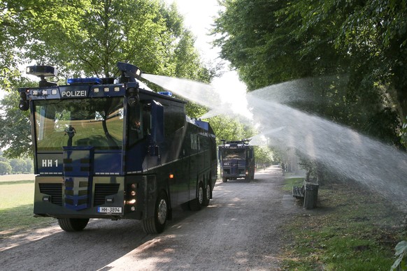 25.07.2018, Hamburg: Wasserwerfer der Hamburger Polizei verspruehen im Stadtpark Wasser auf Baeume und Straeucher. Wegen der anhaltenden Hitze haben Polizeibeamte am Vormittag mit zwei Wasserwerfer Ba ...