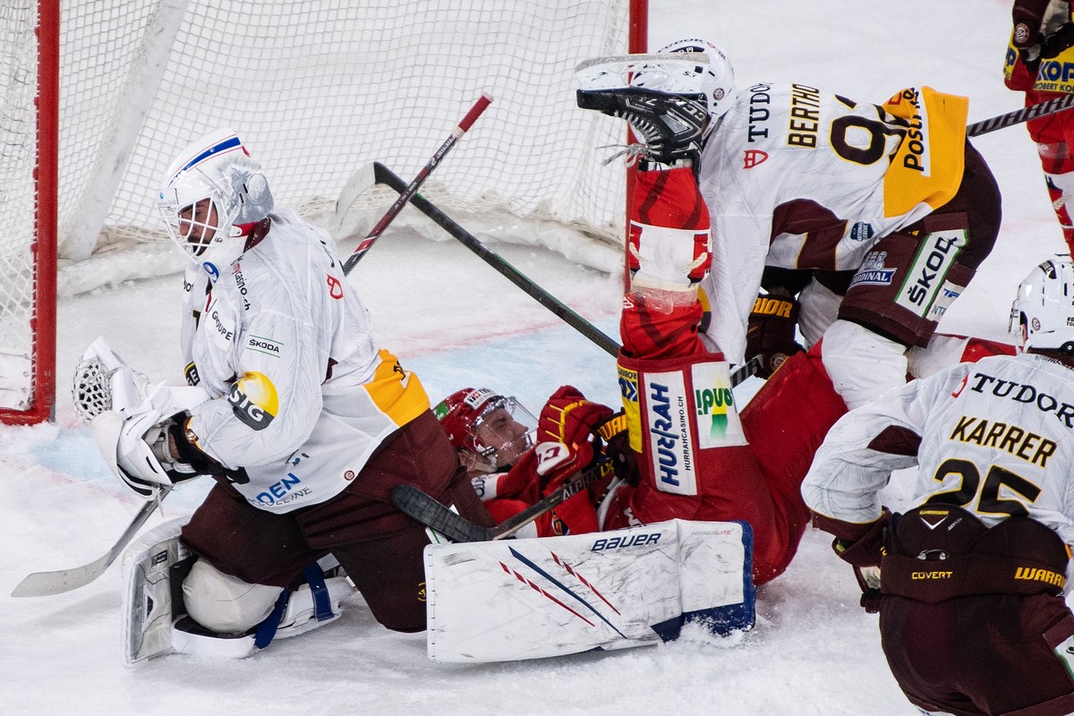 Biels Mike Kuenzle, Mitte,im Duell mit Servettes Torhueter Sandro Zurkirchen, links, und Eliot Berthon im Eishockey Meisterschaftsspiel der National League zwischen dem EHC Biel und Genf Servette HC,  ...