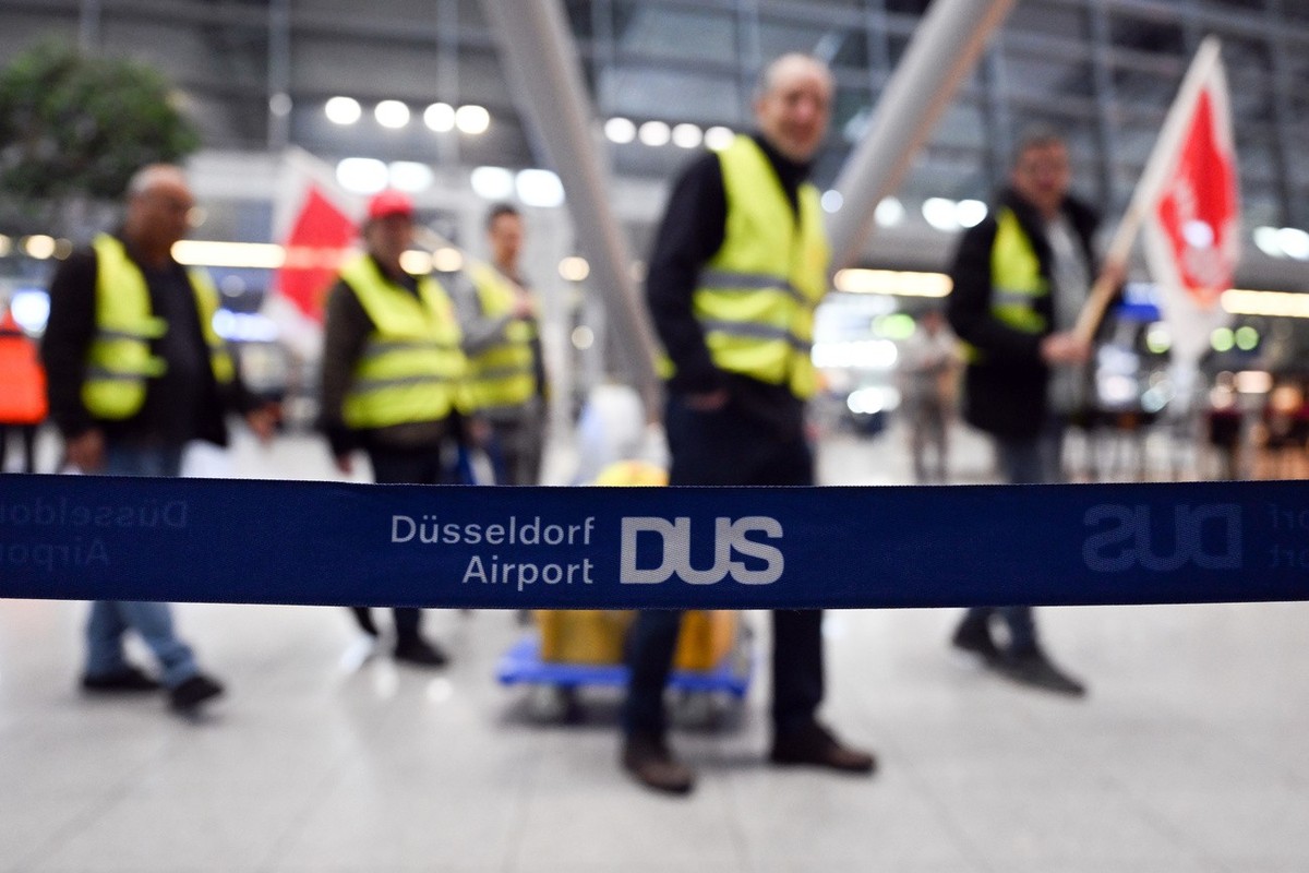 17.03.2023, Nordrhein-Westfalen, D�sseldorf: Streikende Flughafenmitarbeiter gehen durch das Terminal. An den beiden gr��ten Flugh�fen in Nordrhein-Westfalen, D�sseldorf und K�ln/Bonn, haben ganzt�gig ...