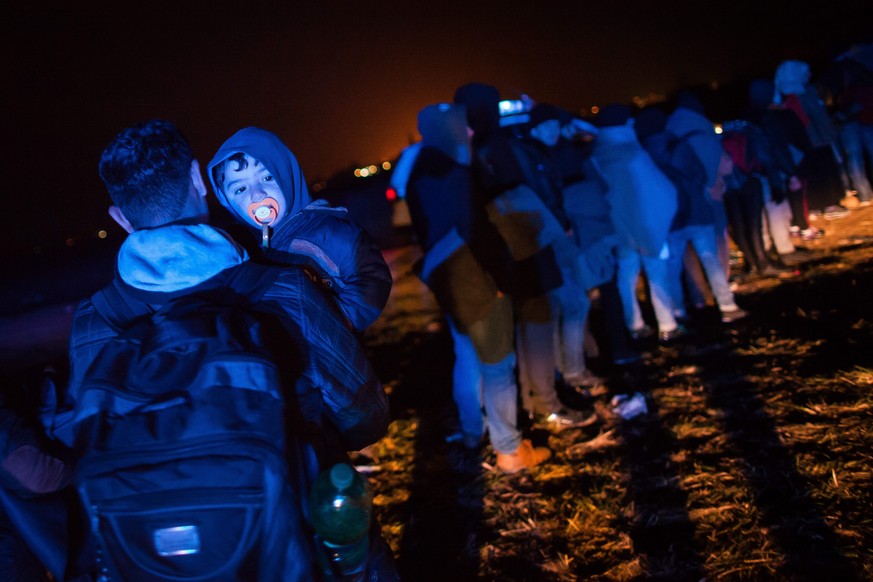 epa04999025 Refugees wait to be further processed at emergency shelters and registration camps before further transport to Austria, in Rigonice, Slovenia, 27 October 2015. Slovenia has become the late ...