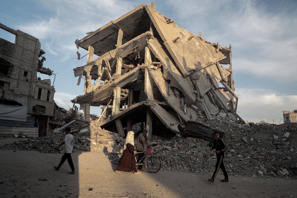 Nahostkonflikt, Gaza, Eindr�cke aus Chan Junis 241014 -- GAZA, Oct. 14, 2024 -- Palestinians are seen on a street with buildings destroyed by Israeli strikes in the southern Gaza Strip city of Khan Yo ...