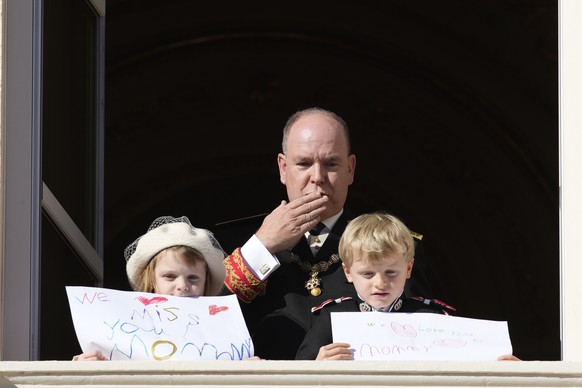 Prince Albert II of Monaco reacts as his children Prince Jacques and Princess Gabriella show messages for their mother Princess Charlene, from the balcony of the the Monaco Palace during ceremonies ma ...