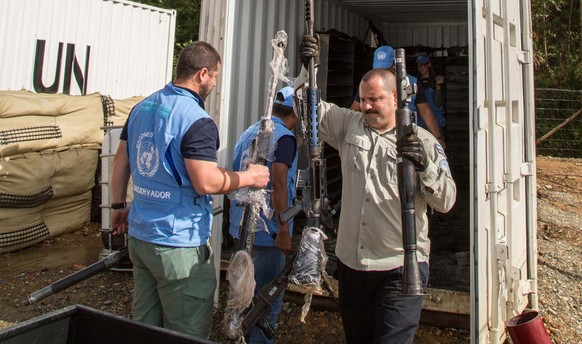 epa06026972 A handout photo made available by the Revolutionary Armed Forces of Colombia (FARC) shows members of the United Nations Mission in Colombia during an inspection of FARC weapons at La Elvir ...