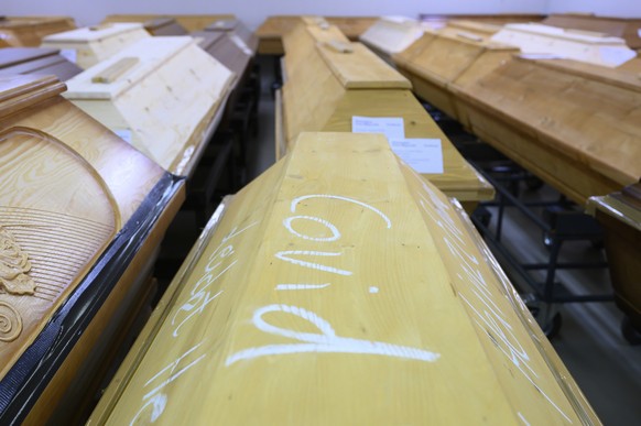 &quot;Covid-19&quot; is marked in chalk on a coffin containing a deceased person who died with the coronavirus, which is in refrigeration with other coffins at the crematorium in Dresden, Germany, Tuesday Dec. 29, 2020.  The crematorium has reached the limit of its capacity due to the high mortality in the Corona pandemic and is now dependent on help from other crematoria. (Sebastian Kahnert/dpa via AP)