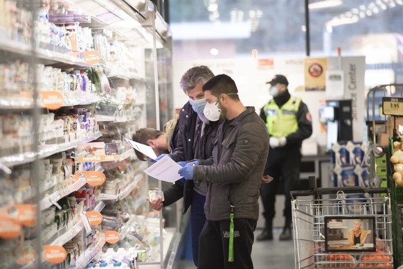 Die Freiwilligenhelfer Adem Salimi, rechts, und Angelo Vellani, links, machen Einkaeufe fuer eine betagte Person, am Montag, 23. Maerz 2020, in Biasca. Aufgrund des Coronavirus verzichten viele aelter ...