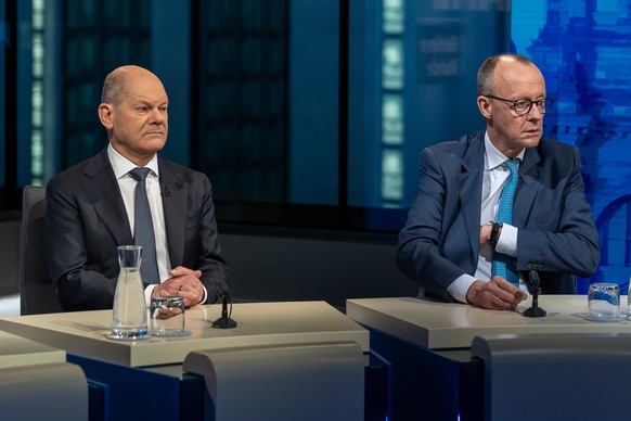epa11919495 German Chancellor Olaf Scholz (L) and Chairman of Germany&#039;s Christian Democratic Union (CDU) Friedrich Merz (R) attend an election night TV talk show at the capital city studio of the ...