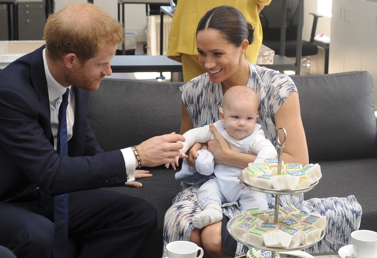 epa07868473 Britain's Prince Harry, The Duke of Sussex (L) and his wife Meghan, Duchess of Sussex (R) holding her son Archie, have tea with Archbishop Desmond Tutu (not pictured) and his daughter ...