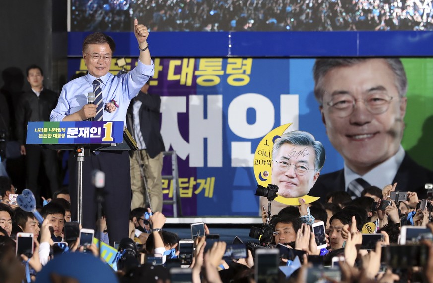 South Korean presidential candidate Moon Jae-in of the Democratic Party gives his supporters a thums-up sign during an election campaign in Seoul, South Korea, Monday, May 8, 2017. Two months after bo ...