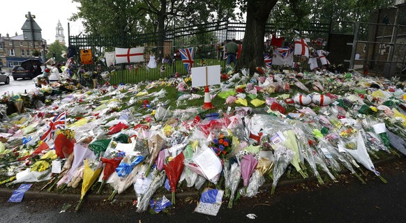 FILE - This Tuesday, May 28, 2013 file photo shows floral tributes at the scene where 25-year-old soldier of the Royal Regiment of Fusiliers Lee Rigby was attacked and killed, near Woolwich Barracks i ...