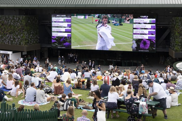 Spectators on Murray Mound (also known as "Henman Hill") watch Stan Wawrinka of Switzerland on a big screen during his second round match against Reilly Opelka of USA, at the All England Law ...