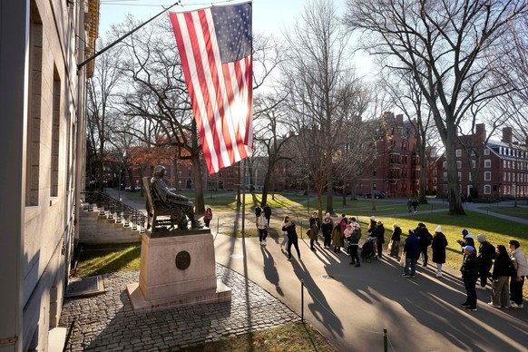 FILE - People take photos near a John Harvard statue, left, on the Harvard University campus, Jan. 2, 2024, in Cambridge, Mass. r. (AP Photo/Steven Senne, File)
Education-Trump-Harvard