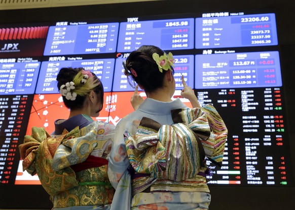 epa06415718 Kimono-clad staff of the Tokyo Stock Exchange of Japan Exchange Group, Inc. point at the opening information of Tokyo&#039;s Nikkei Stock Average (top-R) after the opening ceremony for the ...