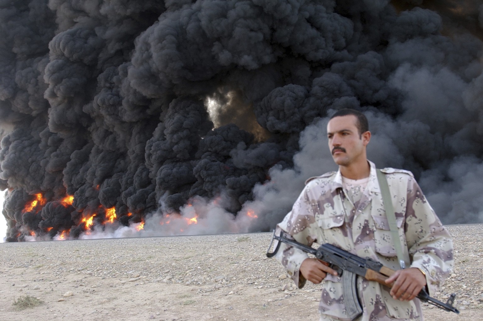FILE - In this Sept. 13, 2005, file photo, an Iraqi soldier secures a burning pipeline near Kirkuk, 290 kilometers (180 miles) north of Baghdad, Iraq. Iraq has invited bidders to express interest to b ...