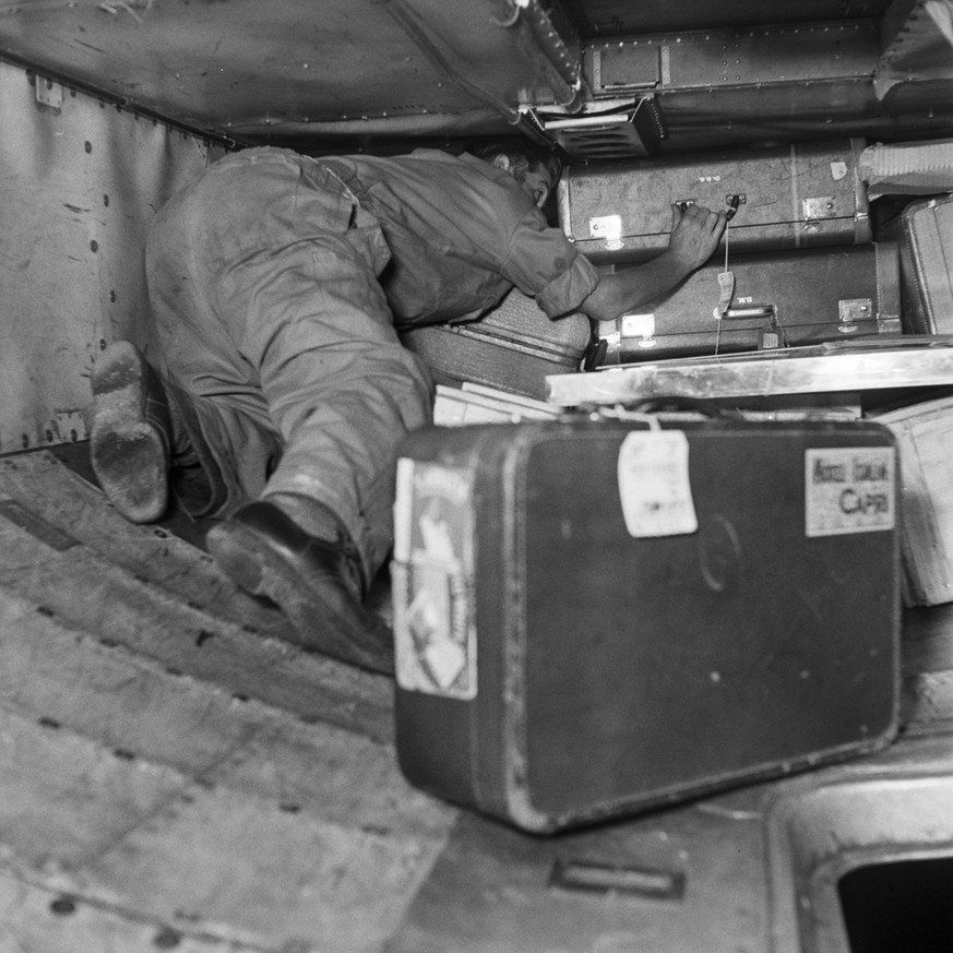 Die etwas andere Weihnachten in der Schweiz - Christnacht am Flughafen Zuerich-Kloten, aufgenommen am 24. Dezember 1958. Der Gepaeckraum einer startbereiten Maschine wird mit Koffern belanden. (KEYSTO ...