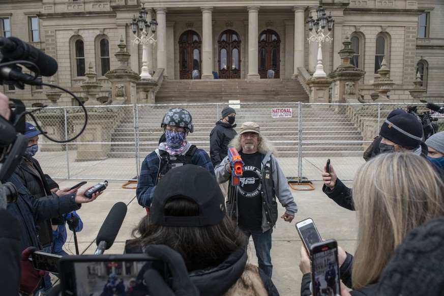 Zwei Mitglieder der rechtsextremem Boogaloo Boys sprechen vor dem Parlament in Lansing (Michigan) mit Reportern.