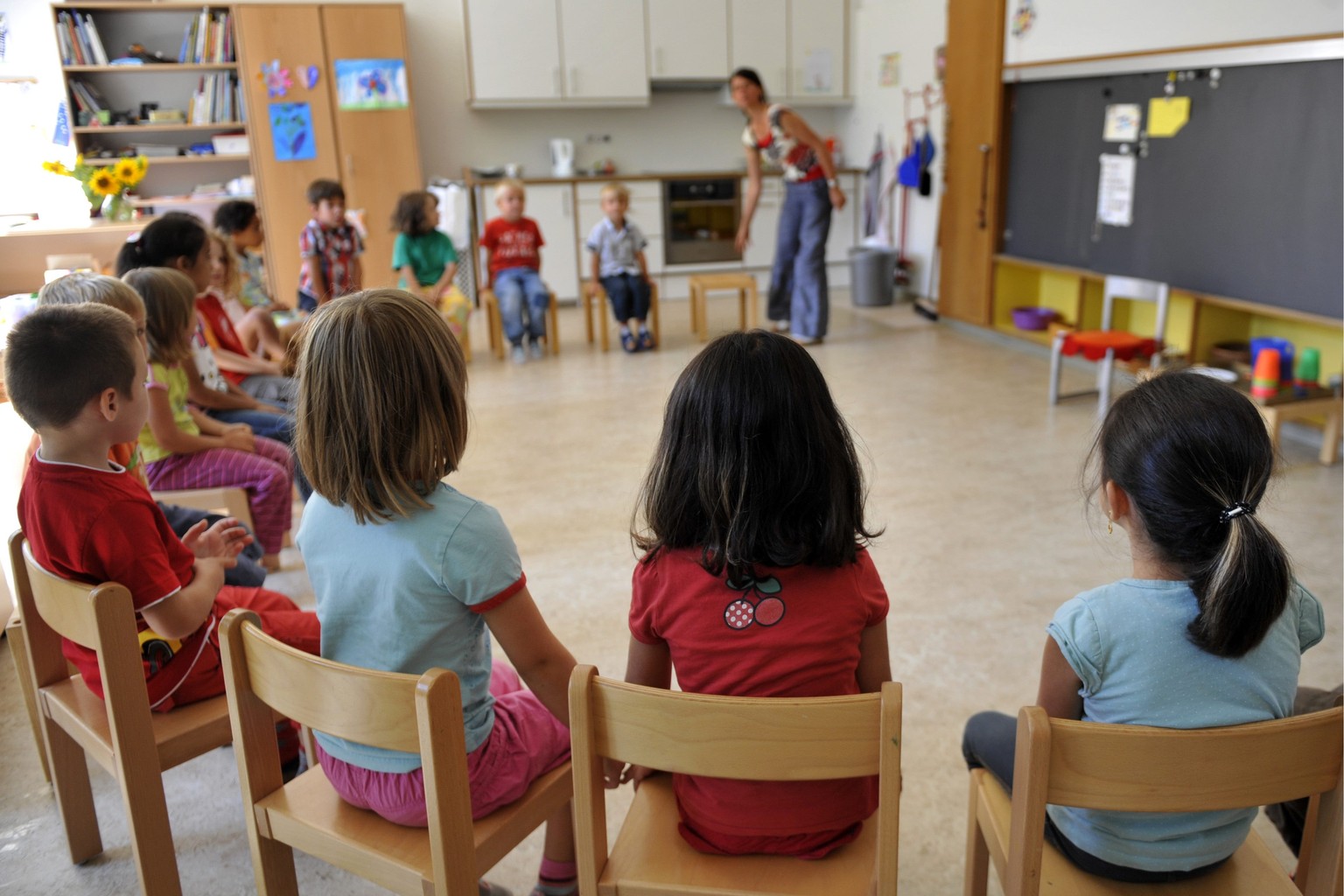 Kinder sitzen im Kreis im Kindergarten Hirzbrunnen in Basel am Montag, 9. August 2010. Gemaess HarmoS-Konkordat ist der Kindergarten Teil der Primarstufe und damit auch Teil der Volksschule. Alle Schu ...