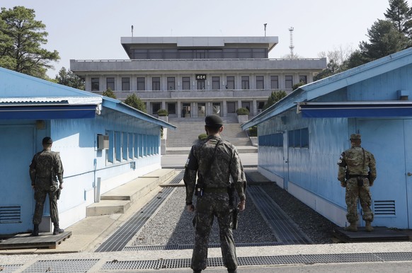 In this Wednesday, April 18, 2018 photo, two South Korean soldiers, center and left, and U.S. soldier, right, stand in the southern side during a press tour at the border village of Panmunjom in the D ...