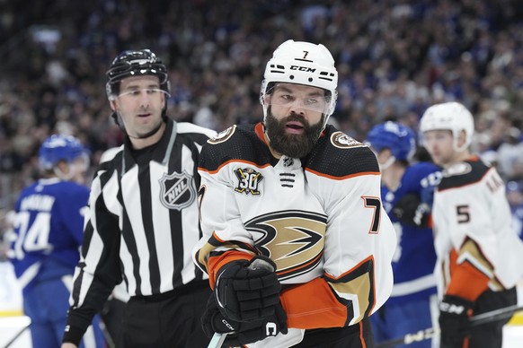 Anaheim Ducks&#039; Radko Gudas is led away by an official after roughing it up with Toronto Maple Leafs&#039; Max Domi during the second period of an NHL hockey game Saturday, Feb. 17, 2024, in Toron ...