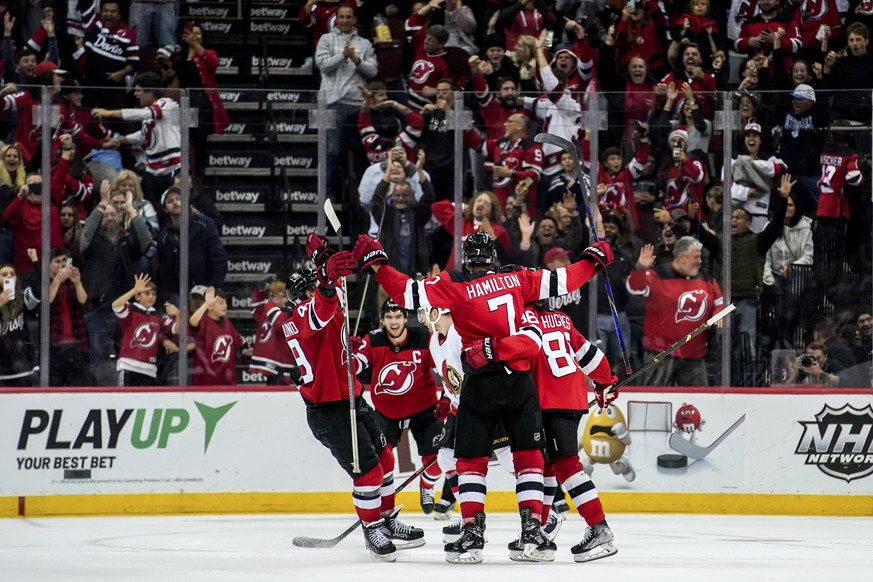 New Jersey Devils center Nico Hischier (13), defenseman Dougie Hamilton (7), left wing Fabian Zetterlund (49) and defenseman Kevin Bahl (88) celebrate Hamilton&#039;s overtime goal in an NHL hockey ga ...