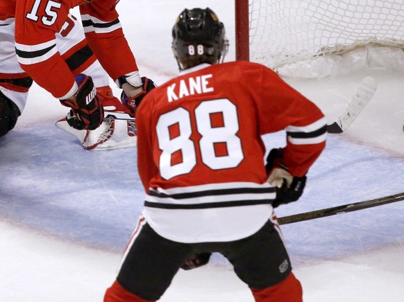 Chicago Blackhawks&#039; Artem Anisimov (15) falls over New Jersey Devils goalie Cory Schneider, after scoring on Schneider, as Patrick Kane (88) and Andy Greene watch during the second period of an N ...