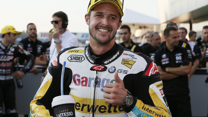 epa05586175 Swiss Moto2 rider Thomas Luethi (C) of Garage Plus Interwetten shows a thumb-up after after placing second in the qualifying of the MotoGP Grand Prix of Japan at Twin Ring Motegi, Tochigi  ...