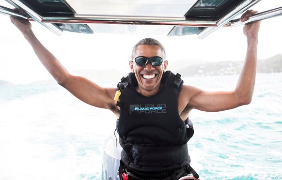 Former U.S. President Barack Obama sits on a boat during a kite surfing outing with British businessman Richard Branson during his holiday on Branson&#039;s Moskito island, in the British Virgin Islan ...