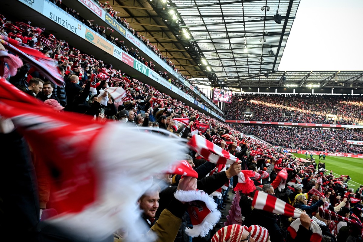 epa09607063 Cologne fans cheer in the stands stand close together prior to the German Bundesliga soccer match between FC Koeln and Borussia Moenchengladbach in Cologne, Germany, 27 November 2021. The  ...