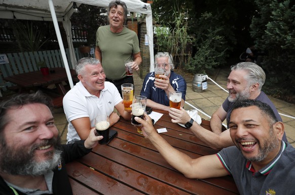 People enjoy their drinks at the Forester pub in London, Saturday, July 4, 2020. England is embarking on perhaps its biggest lockdown easing yet as pubs and restaurants have the right to reopen for th ...