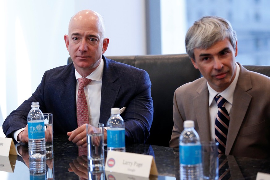 (L-R) Amazon CEO Jeff Bezos and Larry Page, CEO and Co-founder of Alphabet, sit during a meeting with U.S. President-elect Donald Trump and technology leaders at Trump Tower in New York, U.S., Decembe ...