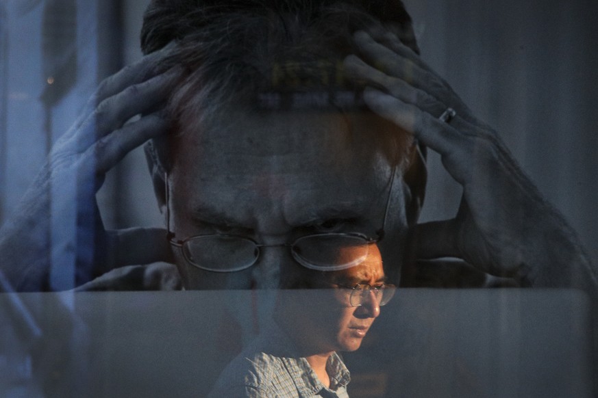 A man is reflected on an advertisement for Apple&#039;s MacBook computer on display near a shopping mall in Beijing, Thursday, Sept. 6, 2018. China&#039;s government says it is ready to retaliate if U ...