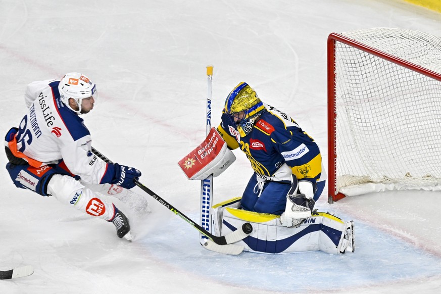 Der Zurcher Dario Trutmann testet den Davoser Torhueter Sandro Aeschlimann, im Eishockey-Qualifikationsspiel der National League (NL) zwischen dem HC Davos und den ZSC Lions, am Sonntag, 19. November  ...