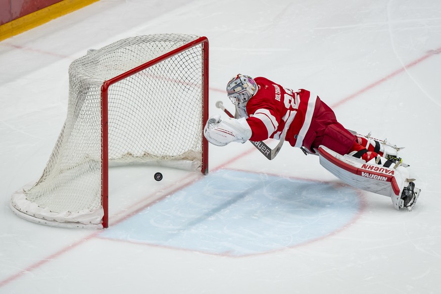 Le gardien lausannois Luca Boltshauser, encaisse un tir au but en prolongation du joueur davosien Dennis Rasmussen lors de la rencontre du championnat suisse de hockey sur glace de National League LNA ...