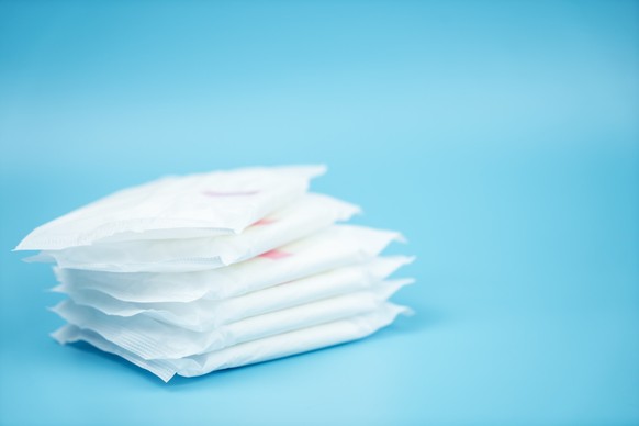 Stacked sanitary napkin pad on blue background., Stacked sanitary napkin pad on blue background., Stacked sanitary napkin pad on blue background., 27.04.2020, Copyright: xBulltusx Panthermedia28369649 ...