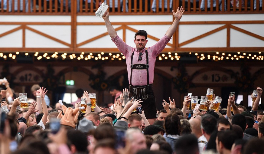 epa07859024 A visitor reacts after downing a mug of beer at the Hofbraeu tent during the opening day of the 186th Oktoberfest beer festival on the Theresienwiese in Munich, Germany, 21 September 2019. ...
