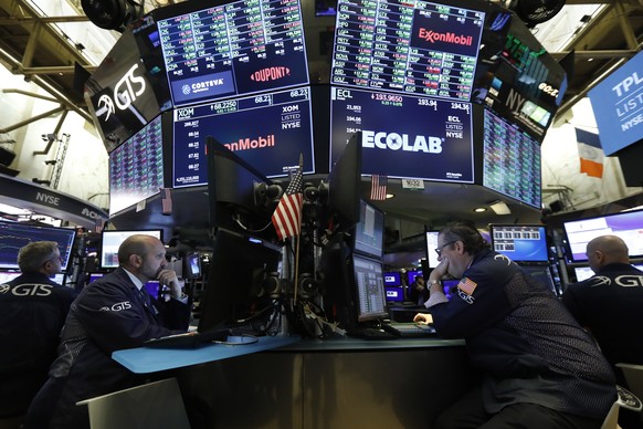 FILE - In this Oct. 21, 2019, file photo specialists James Denaro, left center, and Gregg Maloney, right center, work on the floor of the New York Stock Exchange. President Donald Trump said Thursday, ...