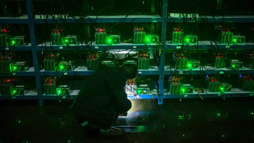epaselect epa06062675 (04/26) Bitcoin miner Huang inspects a malfunctioning mining machine during his night shift at the Bitcoin mine in Sichuan Province, China, 26 September 2016. Miners can check a  ...