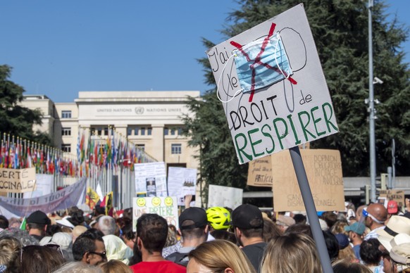 epa08664234 A protester holds a banner reading &#039;right to breathe&#039;&#039; as people from the anti-mask movement protest on the place des Nations in front of the European headquarters of the Un ...