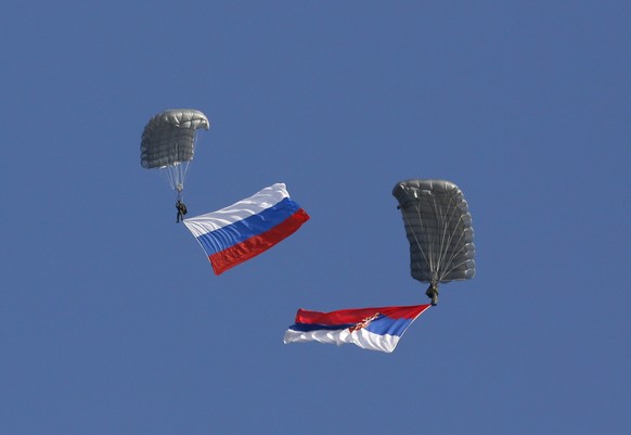 FILE - In this Nov. 14, 2014 file photo, Serbian soldiers parachute from a Mil Mi-8 transport helicopter with a Russian, left, and Serbian flags during the Russian-Serbian joint anti terrorist exercis ...