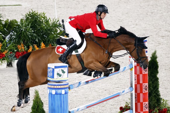 epa09392071 Beat Mandli of Switzerland on Dsarie competes in the Jumping Individual Qualifier during the Equestrian events of the Tokyo 2020 Olympic Games at the Baji Koen Equestrian Park in Setagaya, ...