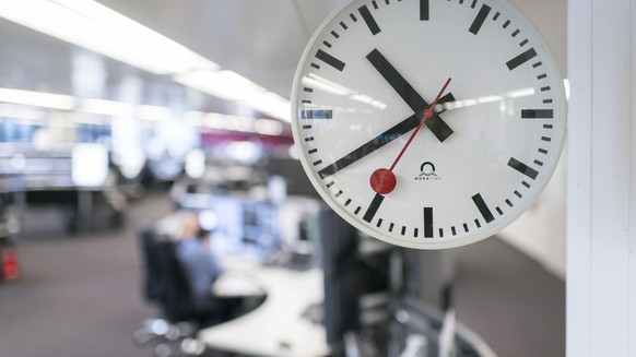 ARCHIV -- ZUM 75. JAHRESTAG DER SCHWEIZERISCHEN BAHNHOFSUHR, STELLEN WIR IHNEN FOLGENDES BILDMATERIAL ZUR VERFUEGUNG -- A SBB clock shows the time, in the background a view of the railway control cent ...