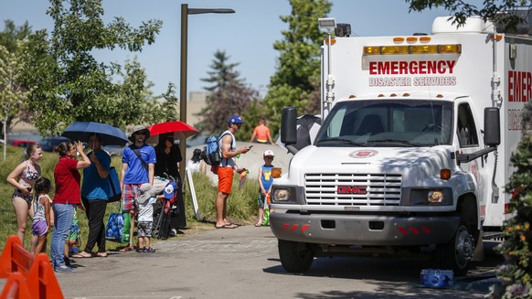 CORRECTS DATE TO WEDNESDAY, JUNE 30, 2021, INSTEAD OF TUESDAY, JUNE 29 FOR PHOTOS: JMC101-111, 113 A Salvation Army EMS vehicle is setup as a cooling station as people lineup to get into a splash park ...