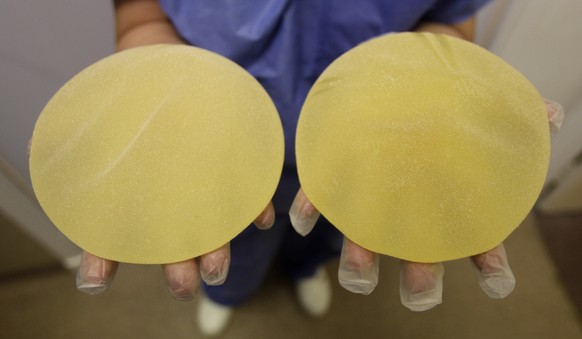 FILE - In this Jan.10, 2012 file photo, a nurse holds defective breast implants manufactured by French company Poly Implant Prothese (PIP), in Nice, southern France. A French appeal court has ruled th ...