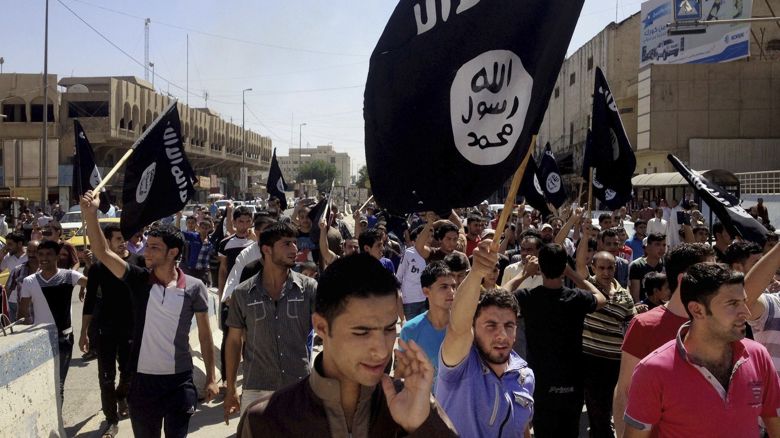 FILE - Demonstrators chant pro-Islamic State group slogans as they carry the group&#039;s flags in front of the provincial government headquarters in Mosul, Iraq, June 16, 2014. The Islamic State grou ...