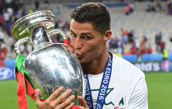 ARCHIV - ZUM RUECKBLICK AUF DIE EM 2016 STELLEN WIR IHNEN FOLGENDES BILDMATERIAL ZUR VERFUEGUNG - epa05419742 Cristiano Ronaldo of Portugal kisses the trophy after winning the UEFA EURO 2016 Final mat ...