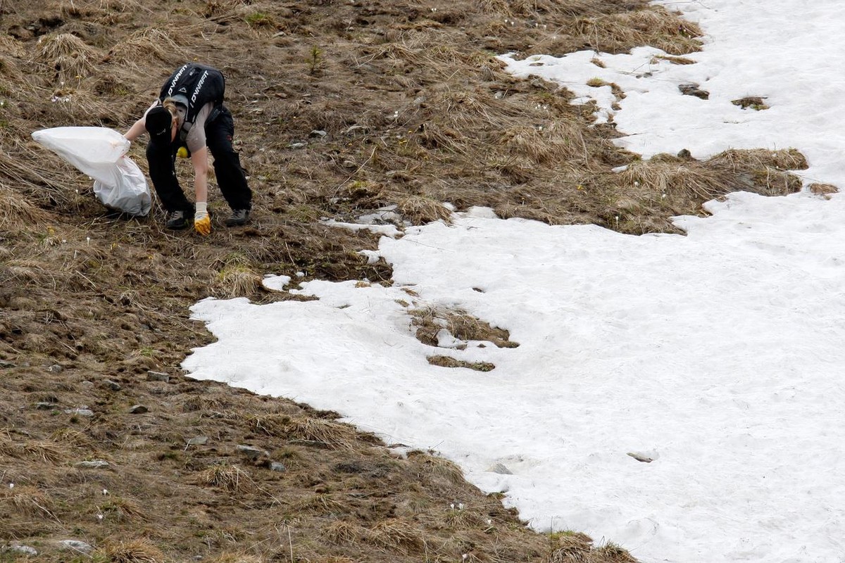 Une benevole ramasse des dechets sur les pistes de ski lors d'une journee "Ramassage des dechets en montagne" ce dimanche 6 juin 2010 a Verbier . (KEYSTONE/Jean-Christophe Bott)