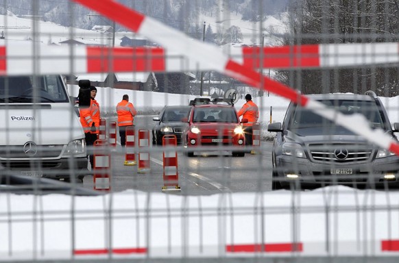 Polizisten ueberpruefen am Mittwoch, 25. Januar 2012, zum Auftakt des WEF die anreisenden Automobilisten in Fideris im Praettigau. Um die Sicherheit rund um das WEF in Davos zu garantieren, wird der A ...