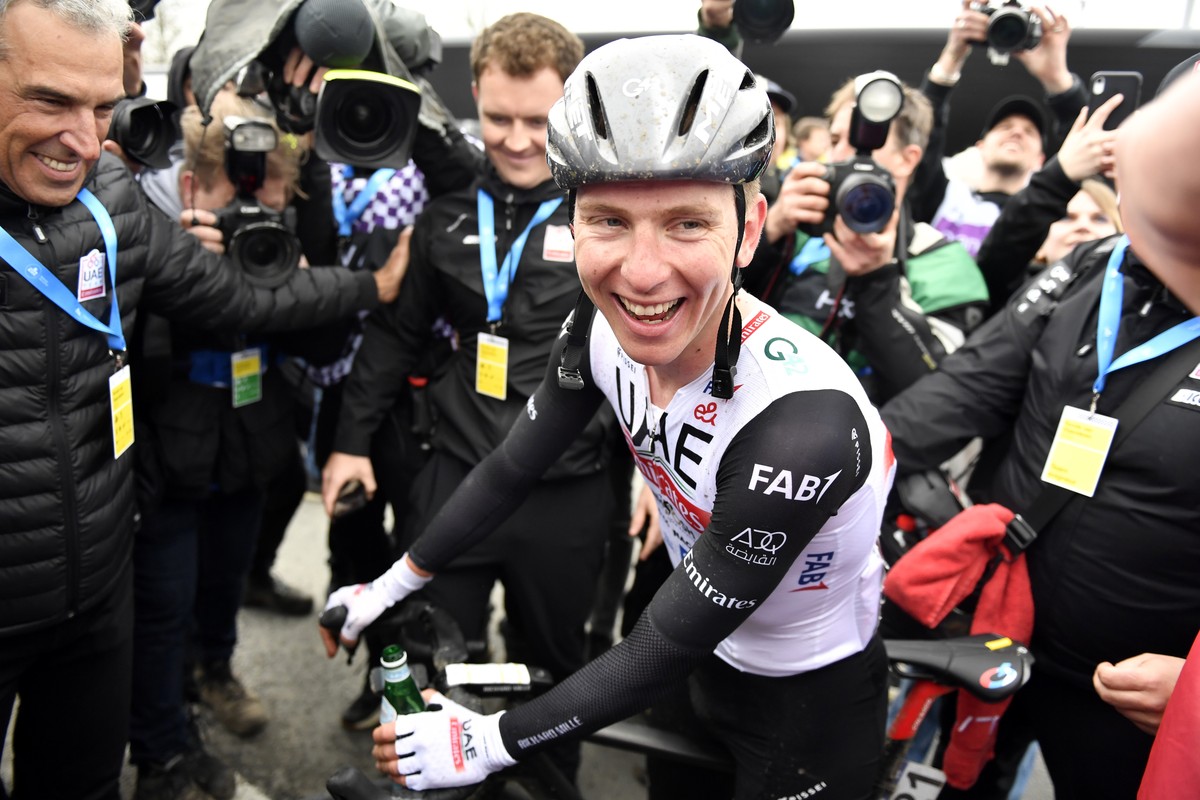 Slovenia's Tadej Pogacar of the UAE Team Emirates is congratulated after crossing the finish line to win the Tour of Flanders in Oudenaarde, Belgium on Sunday, April 2, 2023. (AP Photo/Geert Vand ...